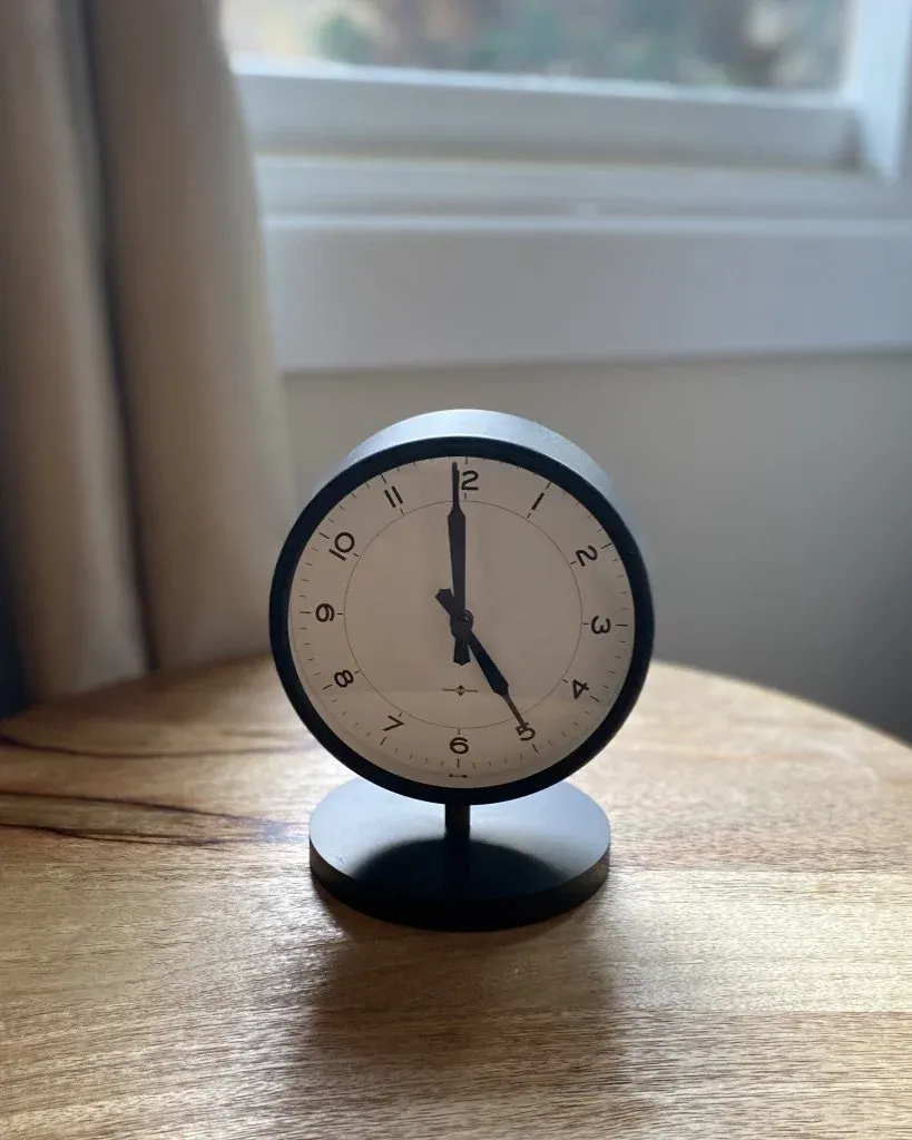 A small alarm clock on a wooden table