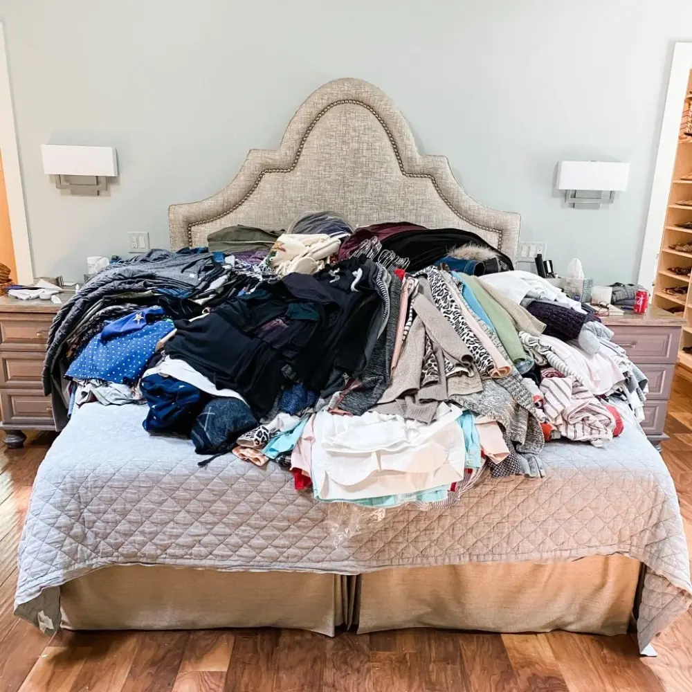 A client's whole wardrobe piled on the bed