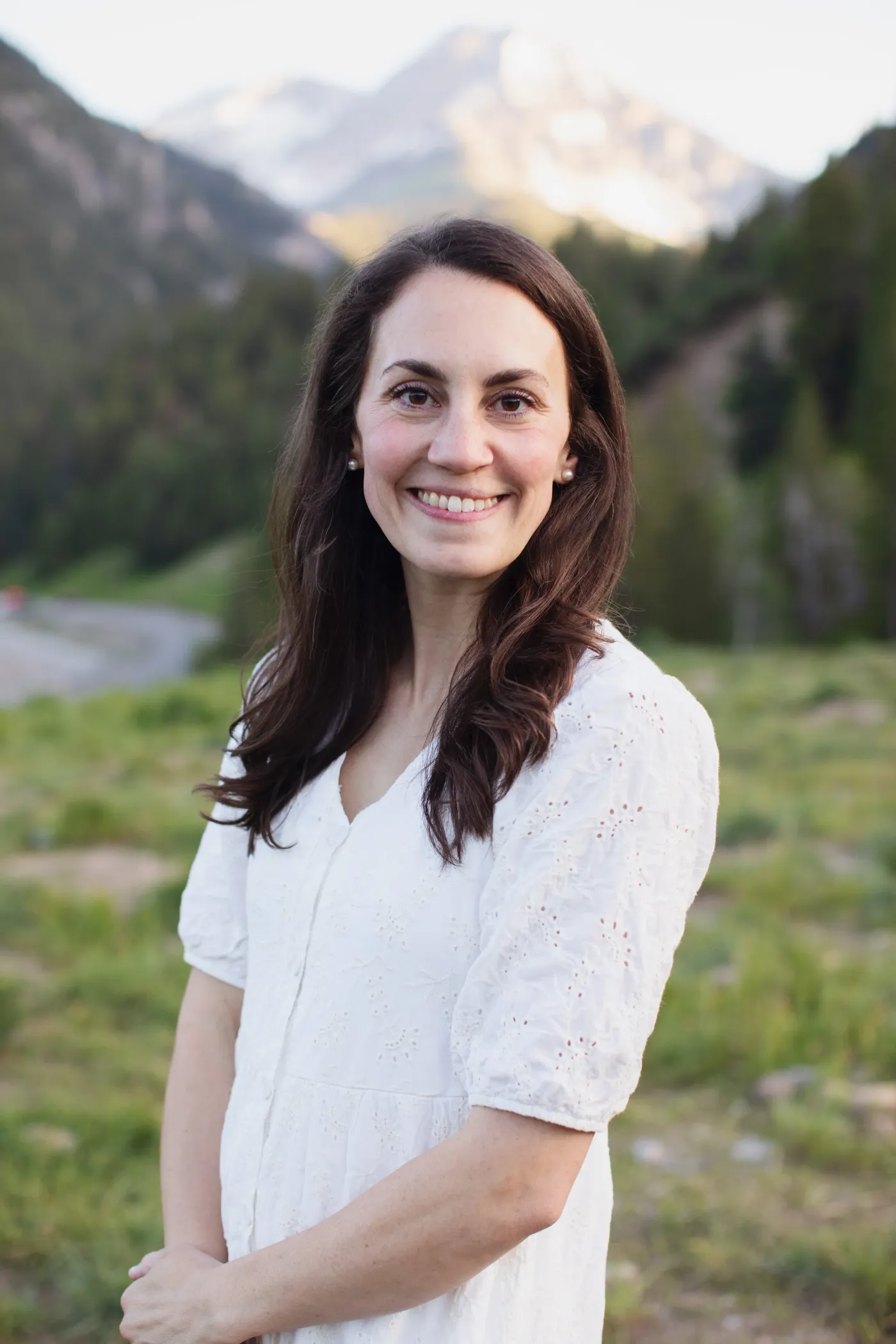Meg, smiling, in a mountain meadow