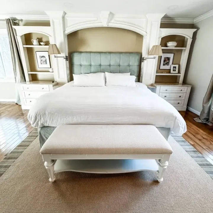 A neatly made bed with white linens